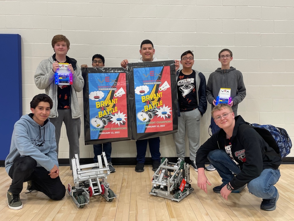 Robotics team posing with winning flags