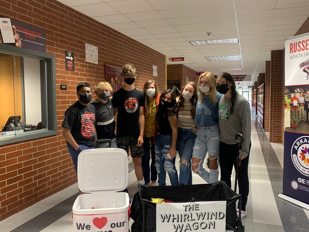 Students pose in front of a black wagon and red cooler that says "we heart our RJHS staff!"