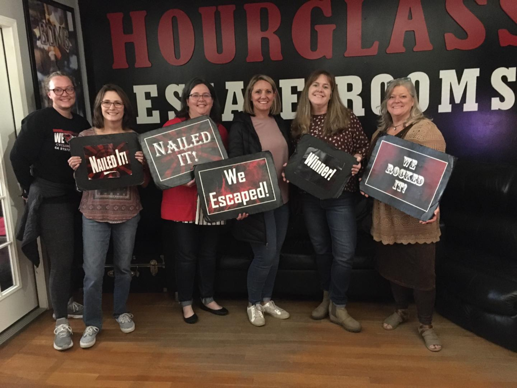 RJHS teachers posing for a picture in an escape room setting