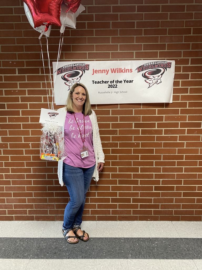 Teacher of the year in front of a banner