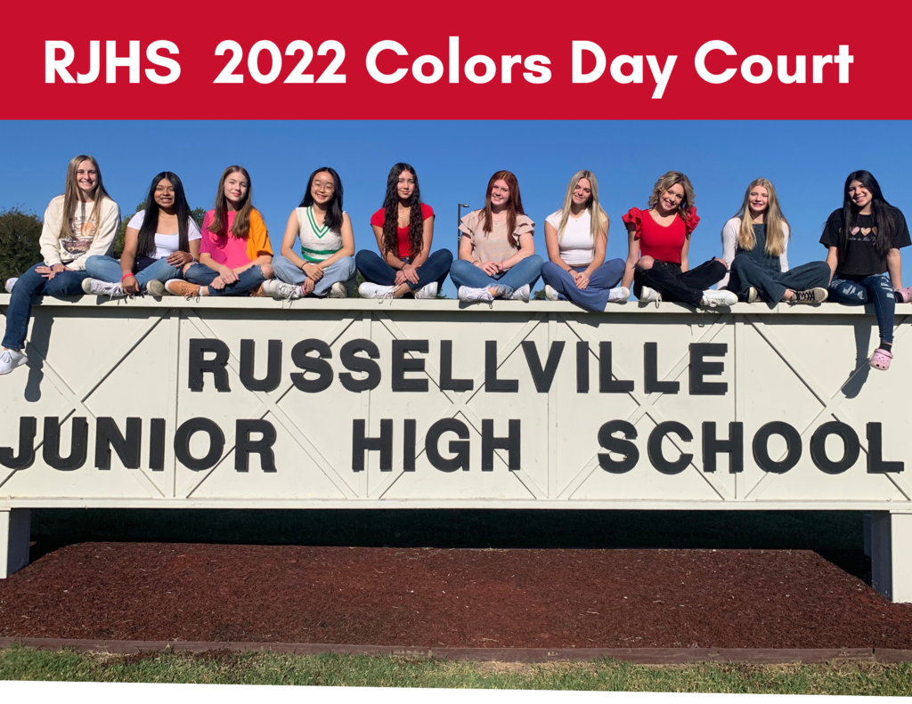 picture of girls sitting on Russellville junior high sign